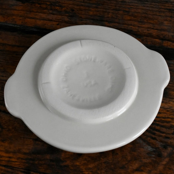 Handcrafted cream-colored stoneware crock cover with side handles, made in USA, designed for food preservation and fermenting in kitchen and pickling collections.