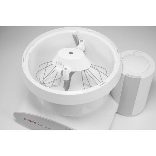 White bowl scraper attachment fitted inside a Bosch mixer bowl with metal whisks, designed to scrape the inner post and sides, handcrafted and made in USA for Kitchen & Food and Baking Supplies collections.