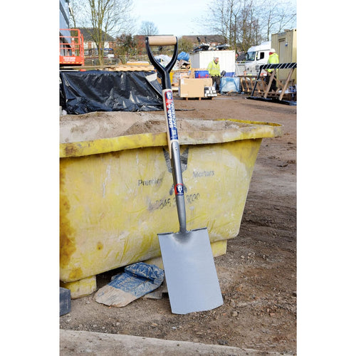 Heavy-duty spade with forged carbon steel blade and D-shaped wooden handle standing upright against a yellow construction skip, perfect for Farm, Garden & Tool, Digging and Cultivating, Lawncare, Best Sellers, and Promo Eligible collections.