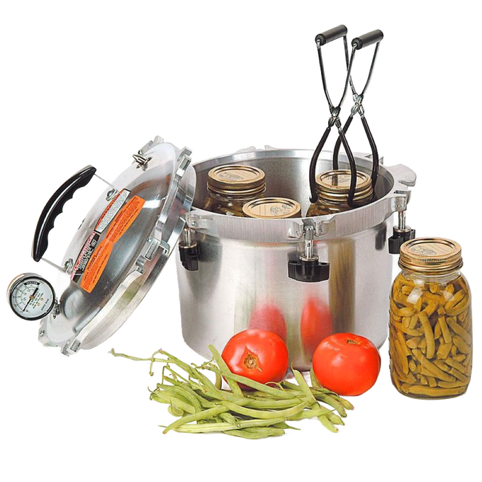 Stainless steel pressure canner with lid open and jars inside, accompanied by fresh green beans and tomatoes, designed for food preservation and pressure canning, made in USA.