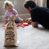 Reusable fabric bag holding 70 handcrafted wooden log pieces for indoor creative play with a child and adult building a fort together, made in USA and featured in Toys, Children's Toys, and Wooden Toys collections.