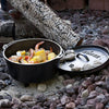 Handcrafted cast iron camp Dutch oven with built-in legs cooking shrimp, corn, and potatoes over hot charcoal, featured in Camping, Cast Iron, USA Made, and Best Sellers collections.
