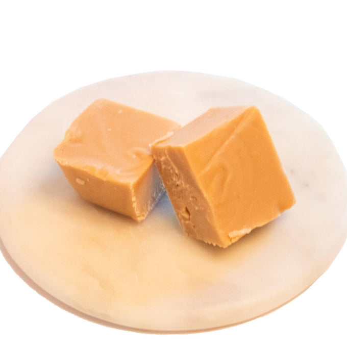 Two handcrafted creamy caramel-colored fudge pieces with a smooth texture on a white marble plate, featured in Kitchen & Food, Snacks and Sweets, USA Made, and Best Sellers collections.