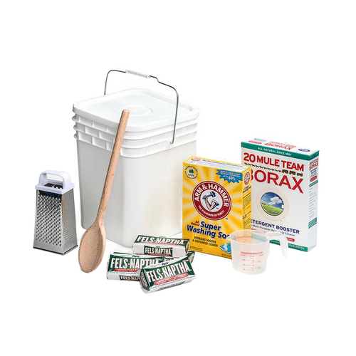 Plastic bucket with lid and metal handle alongside wooden spoon, metal grater, measuring cup, bar soaps, washing soda, and borax for making homemade laundry soap, handcrafted in the USA, suited for home and homesteading uses.