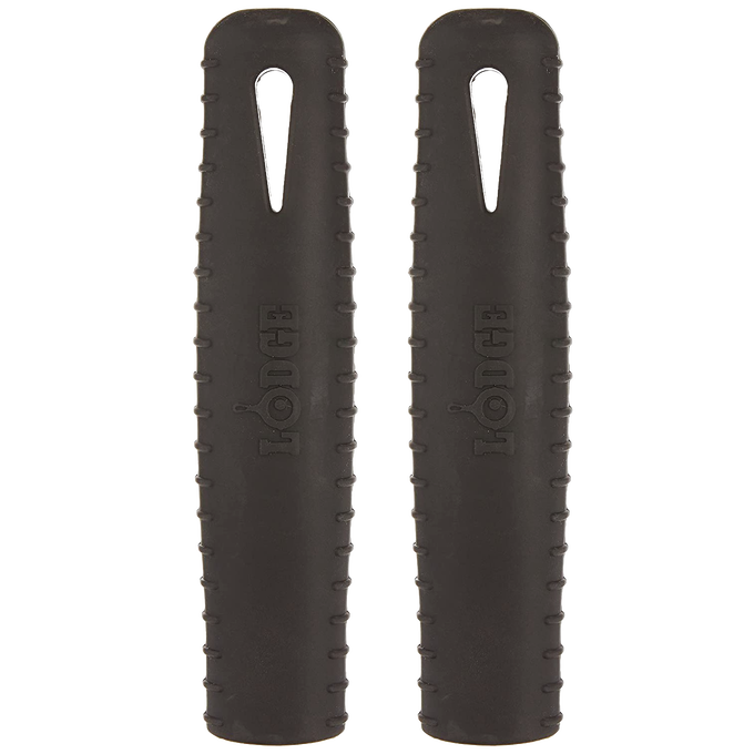Pair of black silicone hot handle holders designed to protect hands from heat on steel skillet handles, featuring ridged grips and dishwasher-safe durability for kitchen use.