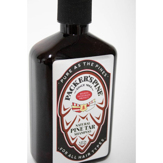 Dark amber bottle of handcrafted natural pine tar shampoo with vintage-style label, featuring pine cone design and highlighting soothing scalp care, from USA Made health and grooming collections.