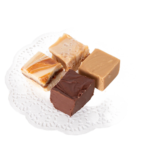 Four handcrafted creamy fudge squares in assorted flavors arranged on a white decorative paper doily, featured in Kitchen & Food and USA Made snack collections.