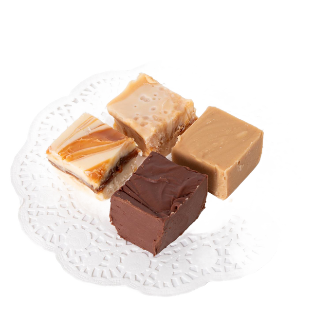 Four handcrafted creamy fudge squares in assorted flavors arranged on a white decorative paper doily, featured in Kitchen & Food and USA Made snack collections.