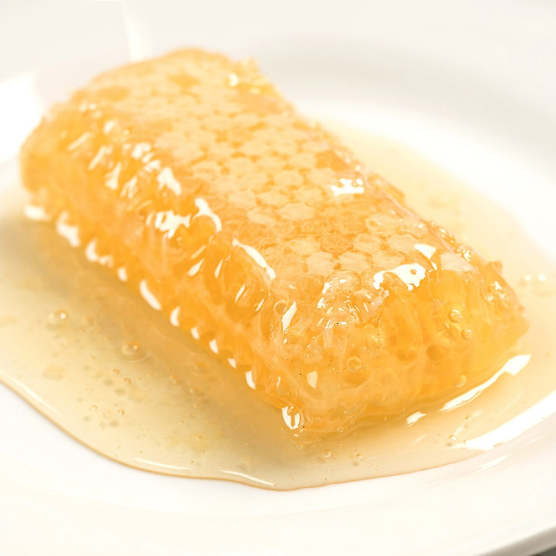 Close-up of a rich, golden honeycomb filled with raw honey resting on a white plate, highlighting a natural, handcrafted treat perfect for Kitchen & Food, Pantry, and USA Made collections.