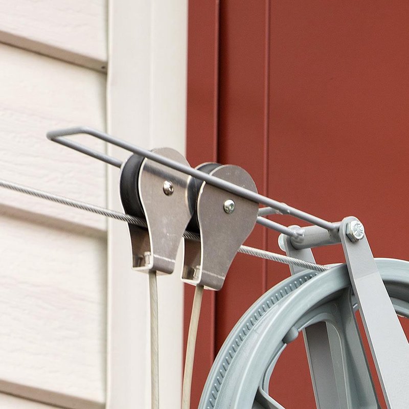 Close-up of a handcrafted metal docking bracket and pulleys securing a clothesline wire, part of a USA made laundry accessory from Home & Decor and Clothesline collections.
