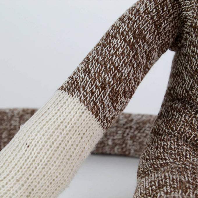 Close-up of a handcrafted arm of a brown and cream knit sock monkey made in USA, featured in Toys, Books & Games, Children's Toys, Indoor Play, and Best Sellers collections.