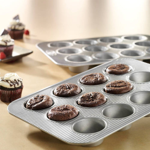 Two durable 12-cup nonstick muffin pans, one with freshly baked chocolate muffins, designed for even heating with a fluted surface, ideal for Kitchen & Food, Baking Supplies, and Cookware collections.