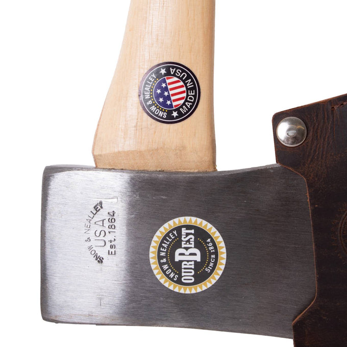 Close-up of a handcrafted Snow & Nealley axe blade forged from high carbon steel with stamped USA branding, featuring a smooth hickory handle and genuine leather blade guard, Amish made for farm and wood cutting tasks.