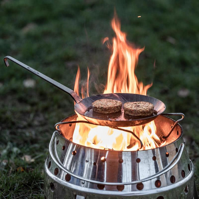 Handcrafted wrought iron pan with long handle cooking two patties over an open flame, suited for Farm, Garden & Tool, Kitchen & Food, Camping, Cookware, Pots and Pans, Best Sellers, and Promo Eligible collections.