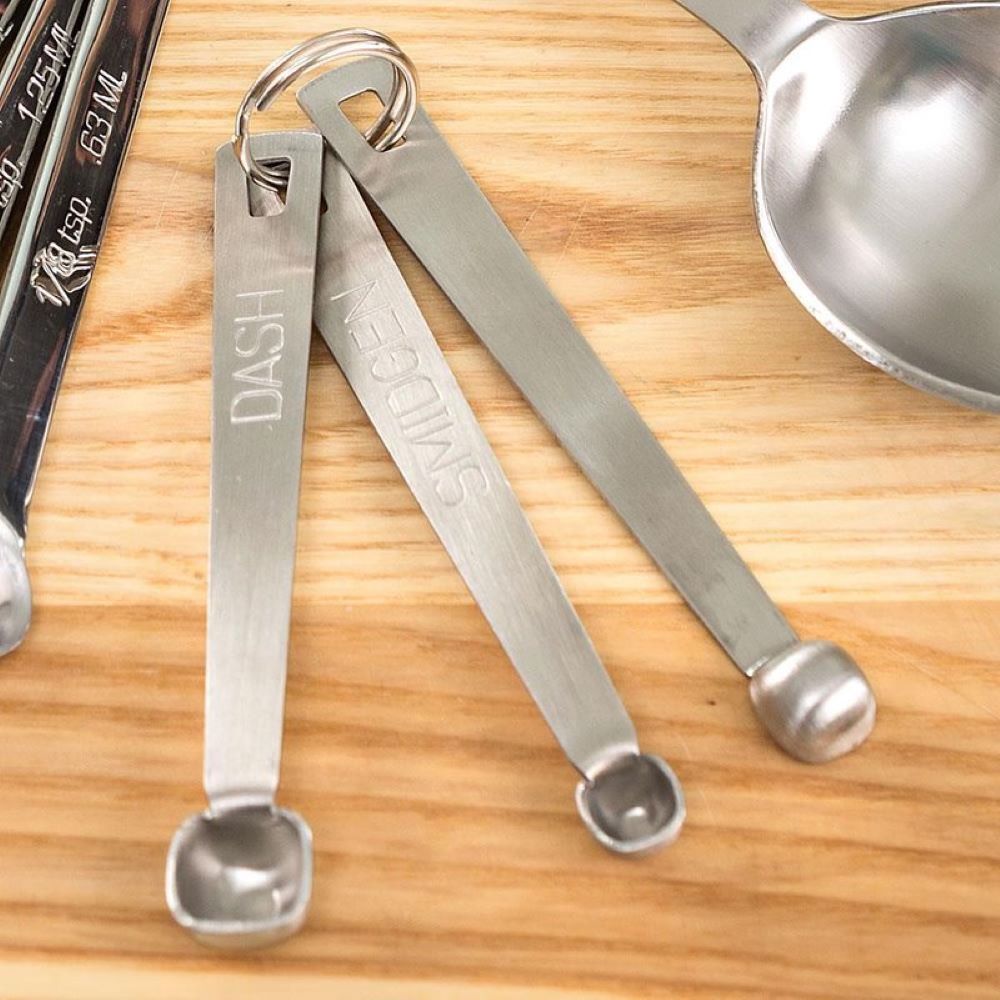 Set of three stainless steel measuring spoons labeled dash, pinch, and smidgen, designed for precise food prep in kitchen gadgets, baking supplies, and cookware collections.
