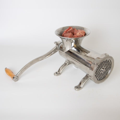 Handcrafted stainless steel mounted meat grinder with smooth wooden handle and chunks of fresh meat ready in the hopper, featured in Kitchen & Food, Specialty Equipment, Butchering Supplies, Best Sellers, Promo Eligible collections.