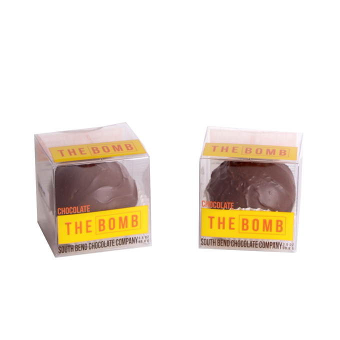 Two handcrafted chocolate hot cocoa spheres in clear boxes with bright yellow "THE BOMB" labels, made in USA, ideal for Kitchen & Food, Snacks and Sweets, Beverages, USA Made, Best Sellers, and Promo Eligible collections.