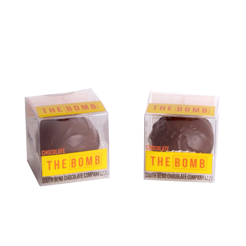 Two handcrafted chocolate hot cocoa spheres in clear boxes with bright yellow "THE BOMB" labels, made in USA, ideal for Kitchen & Food, Snacks and Sweets, Beverages, USA Made, Best Sellers, and Promo Eligible collections.