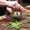 Handcrafted crescent blade knife with wooden handle chopping fresh green beans on a wooden cutting board for Farm, Garden & Tool, Kitchen & Food, and Food Prep collections.