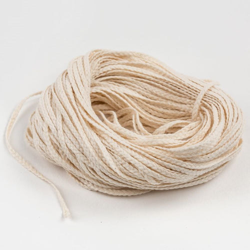 Natural-colored 15 ply flat-braid wick for candlemaking, displayed loosely coiled, suitable for pillar or taper candles, featured in Lamps & Lighting and Candlemaking Supplies collections.