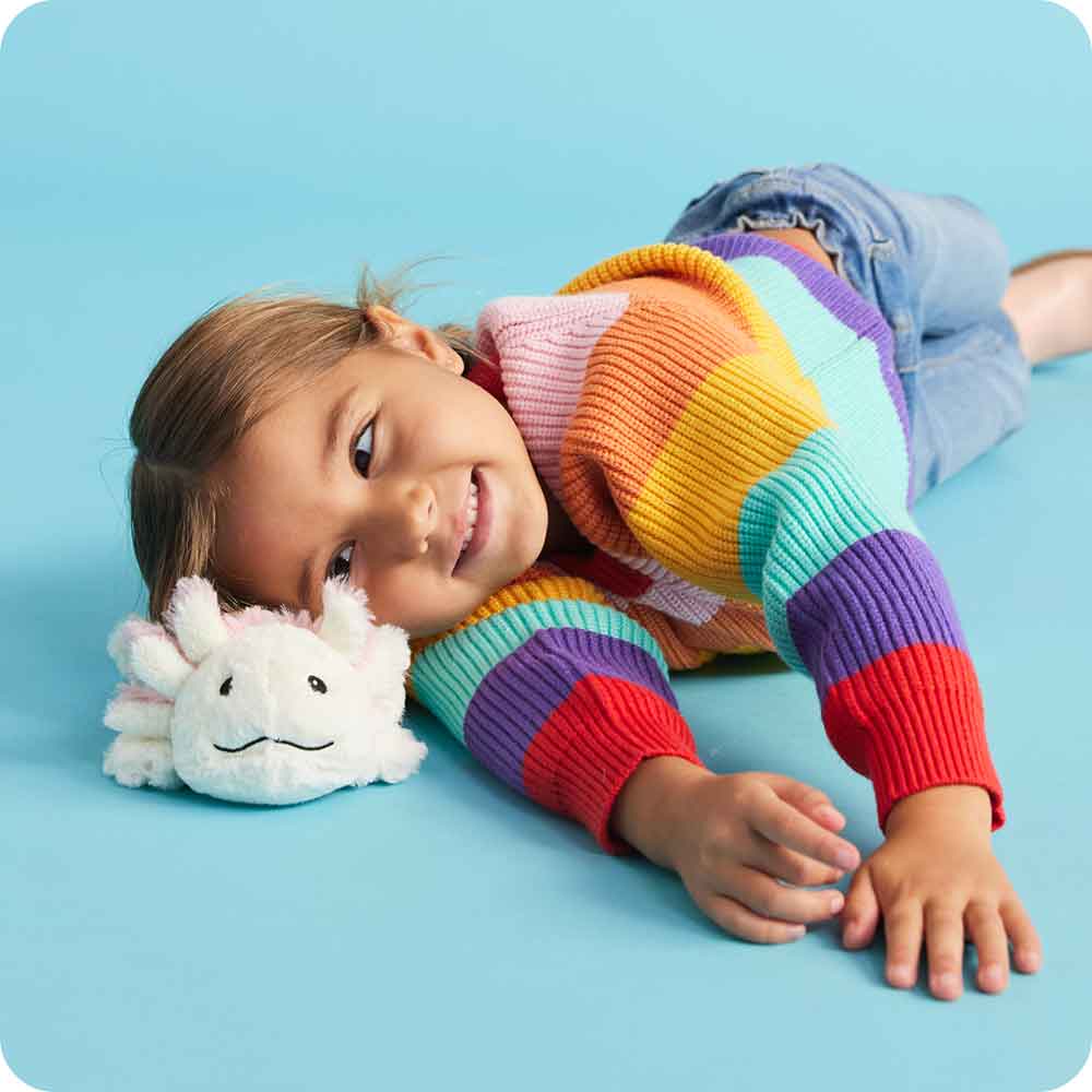 Child resting head on a soft, microwaveable plush animal shaped like a white sea creature with textured details, perfect for Health & Wellness, Children's Toys, and Indoor Play collections.