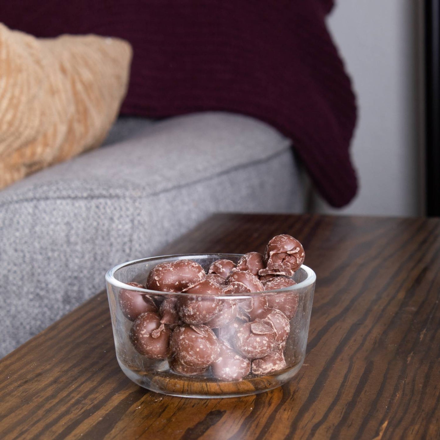 Clear glass bowl filled with handcrafted double dipped chocolate peanuts on a wooden table, a delicious USA made snack from Kitchen & Food, Snacks and Sweets, Candy, Best Sellers, and Promo Eligible collections.