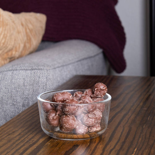 Clear glass bowl filled with handcrafted double dipped chocolate peanuts on a wooden table, a delicious USA made snack from Kitchen & Food, Snacks and Sweets, Candy, Best Sellers, and Promo Eligible collections.