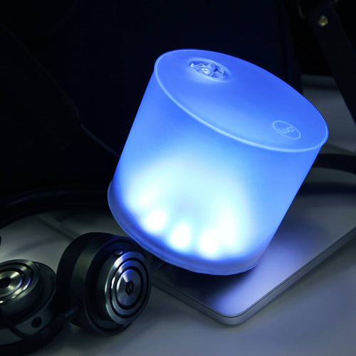 Soft blue glowing handcrafted Luci Color Essence solar light resting on a laptop, ideal for eco-friendly camping, emergency supplies, and indoor Lamps & Lighting use.