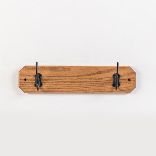Handcrafted oak wallboard with two black metal hooks, Amish made in USA, designed for neat coat organization, featured in Home & Decor, Household Helpers, and Best Sellers collections.
