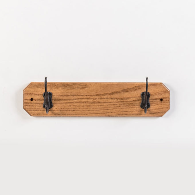 Handcrafted oak wallboard with two black metal hooks, Amish made in USA, designed for neat coat organization, featured in Home & Decor, Household Helpers, and Best Sellers collections.