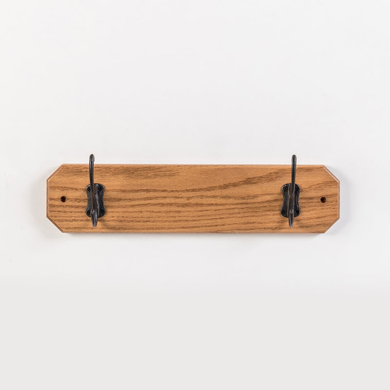 Handcrafted oak wallboard with two black metal hooks, Amish made in USA, designed for neat coat organization, featured in Home & Decor, Household Helpers, and Best Sellers collections.