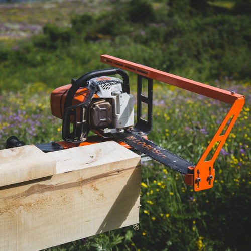 Orange metal bar nose top steering accessory attached to a chainsaw, positioned on a large wooden log outdoors, designed for precise guide bar adjustment in wood cutting, featured in Farm, Garden & Tool and Wood Cutting and Hauling collections.