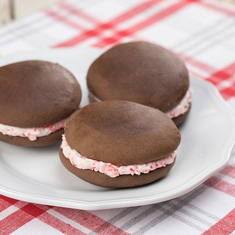 Three soft chocolate cake-like sandwiches with fluffy peppermint cream filling on a white plate, handcrafted in the USA, ideal for Kitchen & Food and Snacks and Sweets collections.