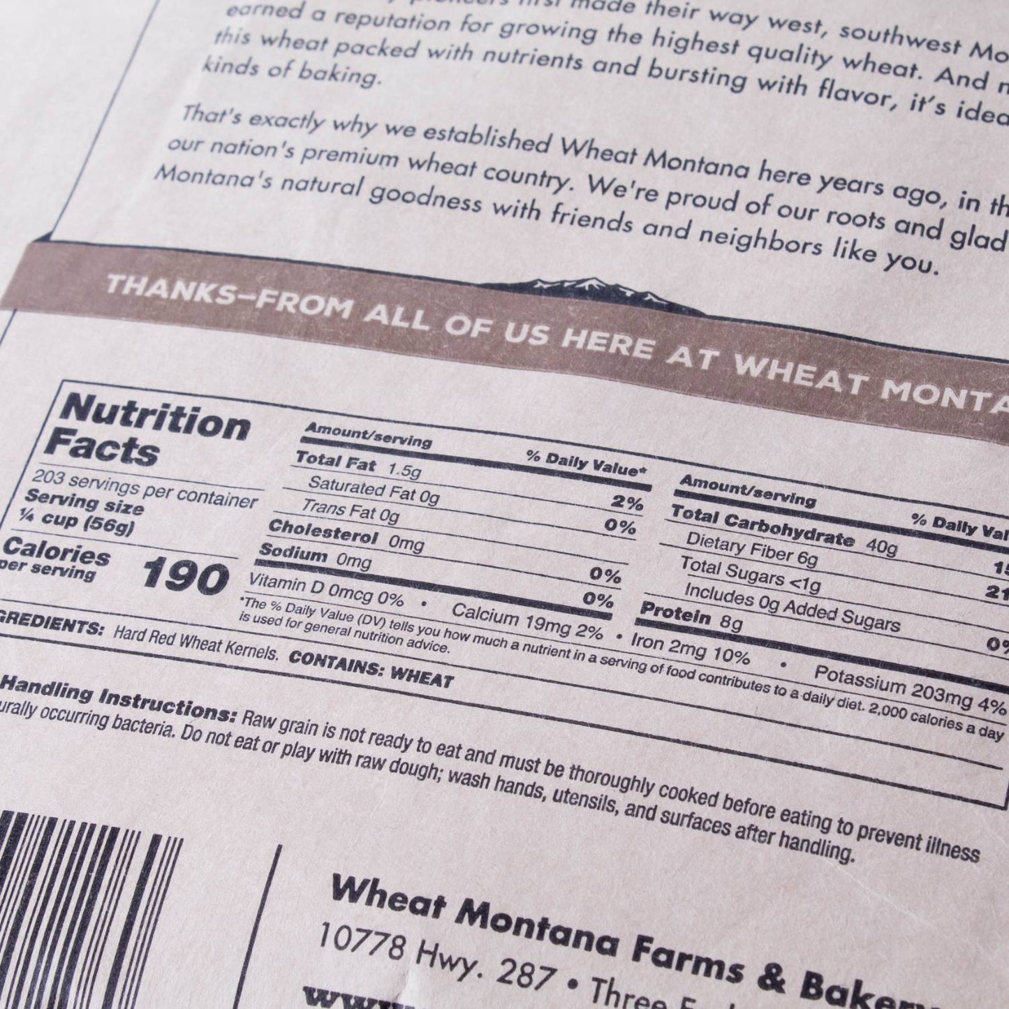 Close-up of nutrition facts and ingredient label on a package of hard red wheat berries, highlighting protein content and usage instructions for bread making and pantry supplies.