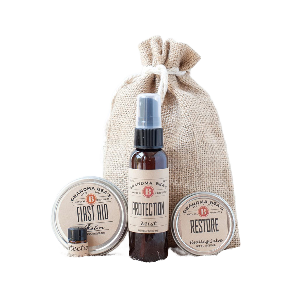 Compact wellness kit featuring natural first aid balm, protection essential oil blend, and restore healing salve in a handcrafted burlap bag, ideal for Health & Wellness collections.