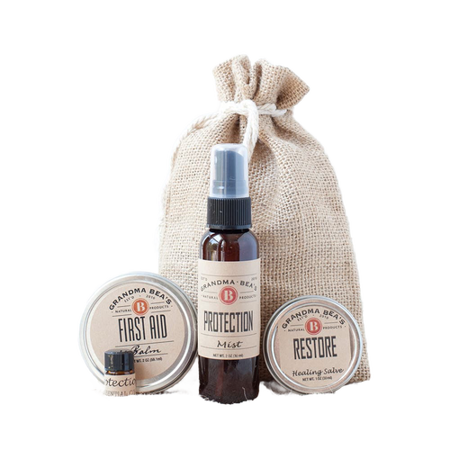 Compact wellness kit featuring natural first aid balm, protection essential oil blend, and restore healing salve in a handcrafted burlap bag, ideal for Health & Wellness collections.