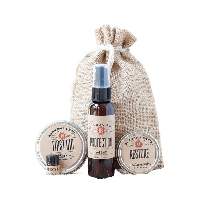 Compact wellness kit featuring natural first aid balm, protection essential oil blend, and restore healing salve in a handcrafted burlap bag, ideal for Health & Wellness collections.