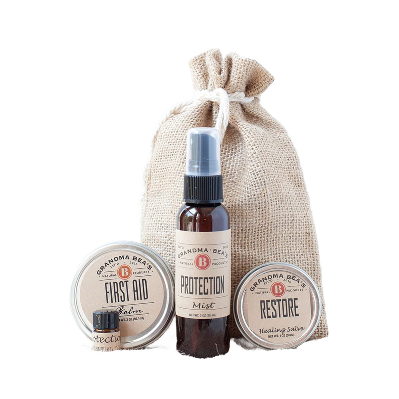Compact wellness kit featuring natural first aid balm, protection essential oil blend, and restore healing salve in a handcrafted burlap bag, ideal for Health & Wellness collections.