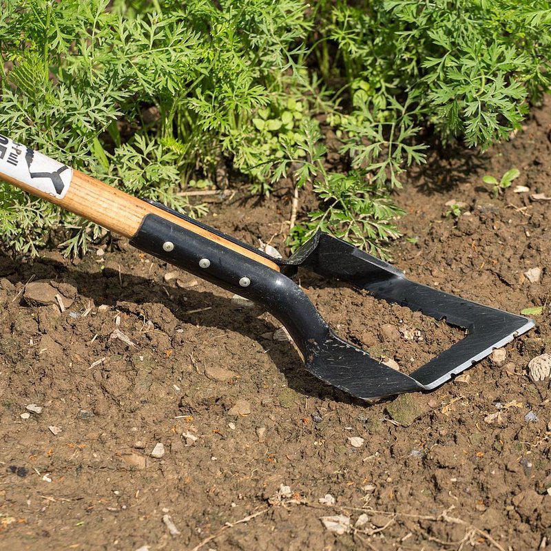 Handcrafted push-pull garden hoe with a long ash handle and hardened serrated steel blade, designed for efficient weed removal in farm, garden, and lawncare tasks, USA made.