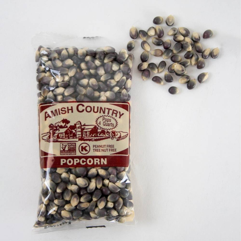 Clear plastic bag of handcrafted Amish Country popcorn kernels in a distinctive purple and tan blend, shown with loose kernels on a white surface, ideal for Kitchen & Food and USA Made collections.