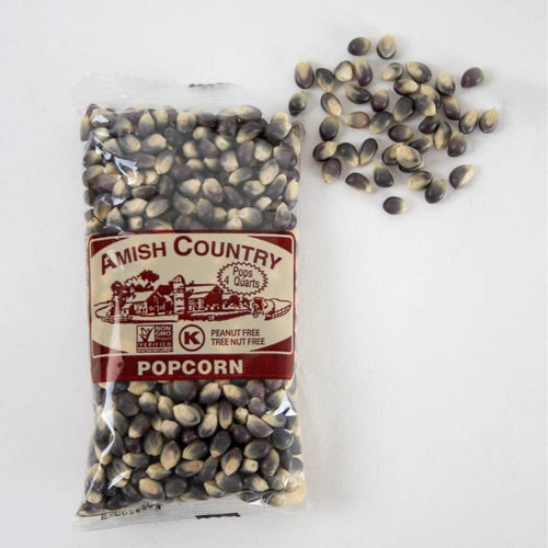 Clear plastic bag of handcrafted Amish Country popcorn kernels in a distinctive purple and tan blend, shown with loose kernels on a white surface, ideal for Kitchen & Food and USA Made collections.