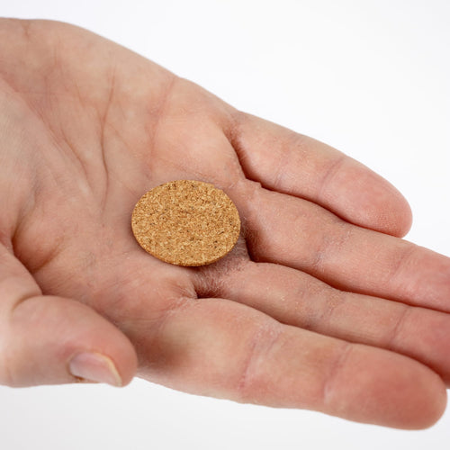 Hand holding a small round cork seal gasket designed for fuel caps, featured in lamps & lighting, parts and accessories, other parts, best sellers, and promo eligible collections.