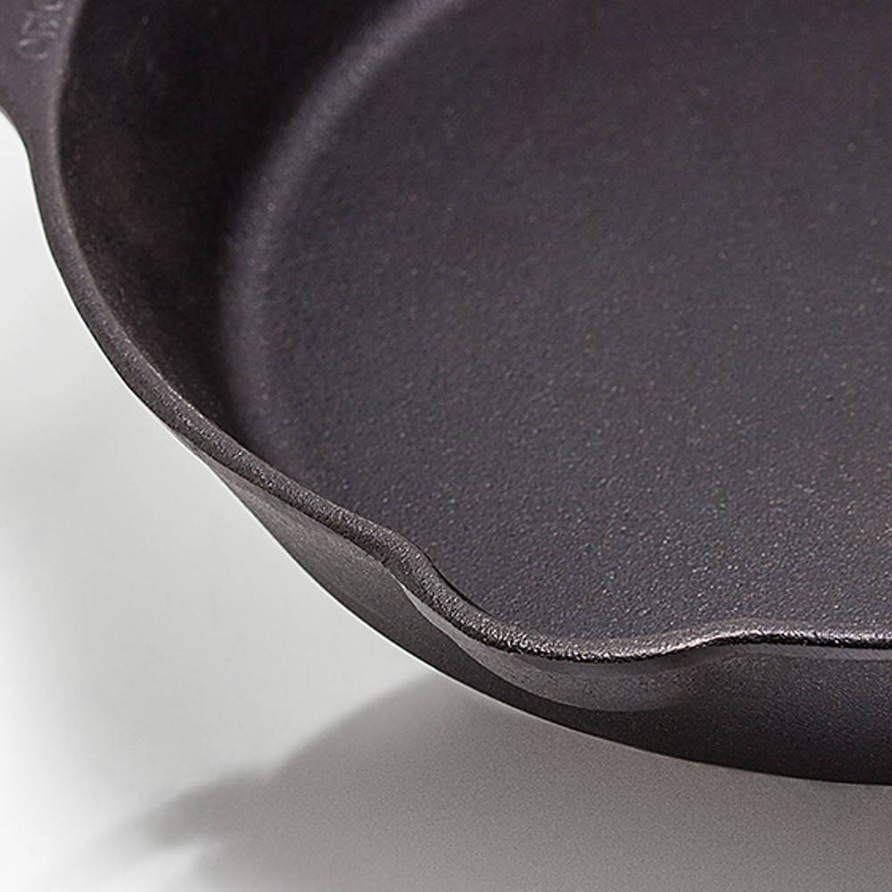 Close-up of a heavy-duty cast iron skillet featuring a long handle and dual pouring spouts, designed for versatile use in Farm, Garden & Tool, Camping, Kitchen & Food, and Best Sellers collections.