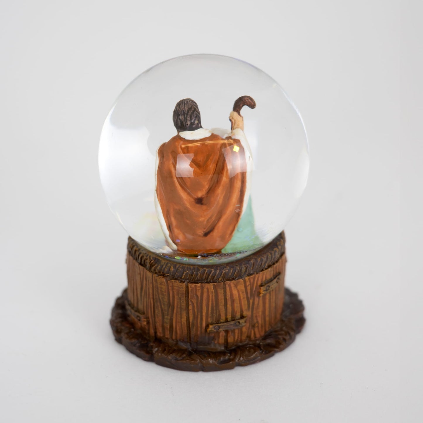 Handcrafted miniature snow globe featuring a detailed Nativity scene with the Holy Family inside a clear globe, set on a rustic wood-textured base, ideal for Home & Decor and Holiday Decor collections.