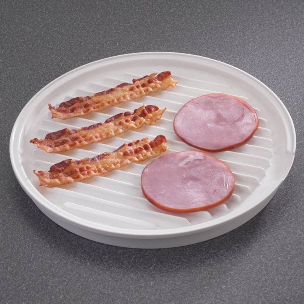 Round white microwaveable grill with raised ribbed surface draining fat from crispy cooked bacon strips and slices of ham, designed for healthier cooking, USA made, Kitchen Gadgets.