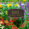 Black custom lawn plaque with raised border displaying address number and street name, set among colorful garden flowers, crafted in USA for Home & Decor and Mailboxes collections.
