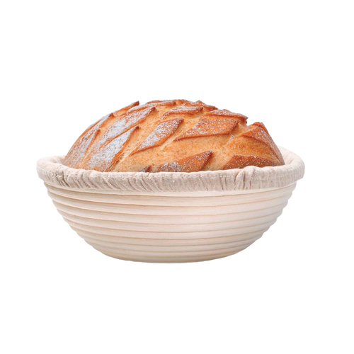 Handcrafted rattan bread proofing basket with a removable cloth liner holding a freshly scored artisan loaf, ideal for Kitchen & Food, Baking Supplies, and Bread Making collections.
