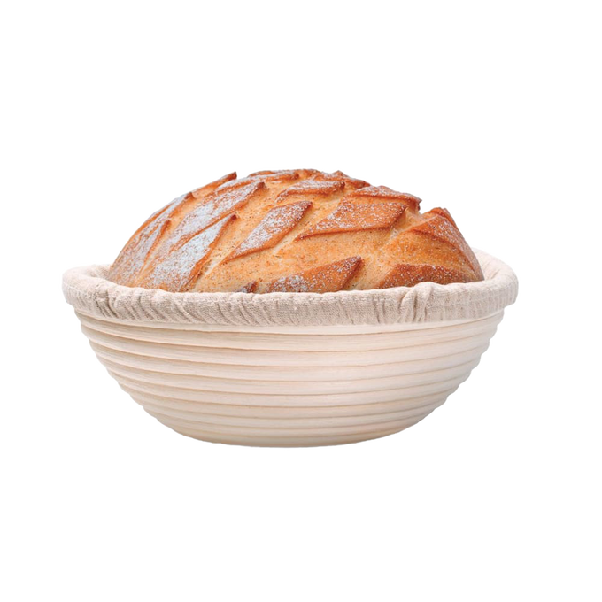 Handcrafted rattan bread proofing basket with a removable cloth liner holding a freshly scored artisan loaf, ideal for Kitchen & Food, Baking Supplies, and Bread Making collections.