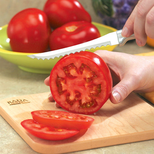 Handcrafted high carbon stainless steel tomato slicer cutting thin slices on a fresh red tomato over a wooden board, ideal for kitchen knives, food prep, and USA Made collections.