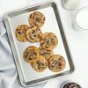 Aluminized steel quarter sheet pan holding freshly baked chocolate chunk cookies sprinkled with sea salt, presented with milk and baking ingredients, ideal for Kitchen & Food, Cookware, Baking Supplies, Pots and Pans, USA Made, Best Sellers, and Promo Eligible collections.